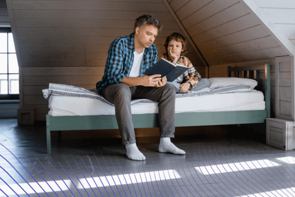 Otec s malým synom čítajú knihu v detskej izbe s podlahovkou
